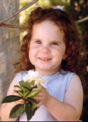 A close-up of a child holding a flower

Description automatically generated