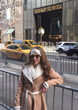 A person leaning against a metal fence

Description automatically generated
