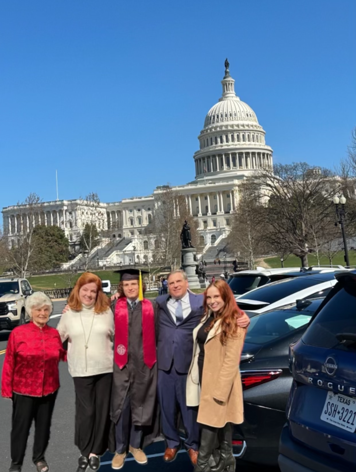 A group of people posing for a picture in front of a building

Description automatically generated