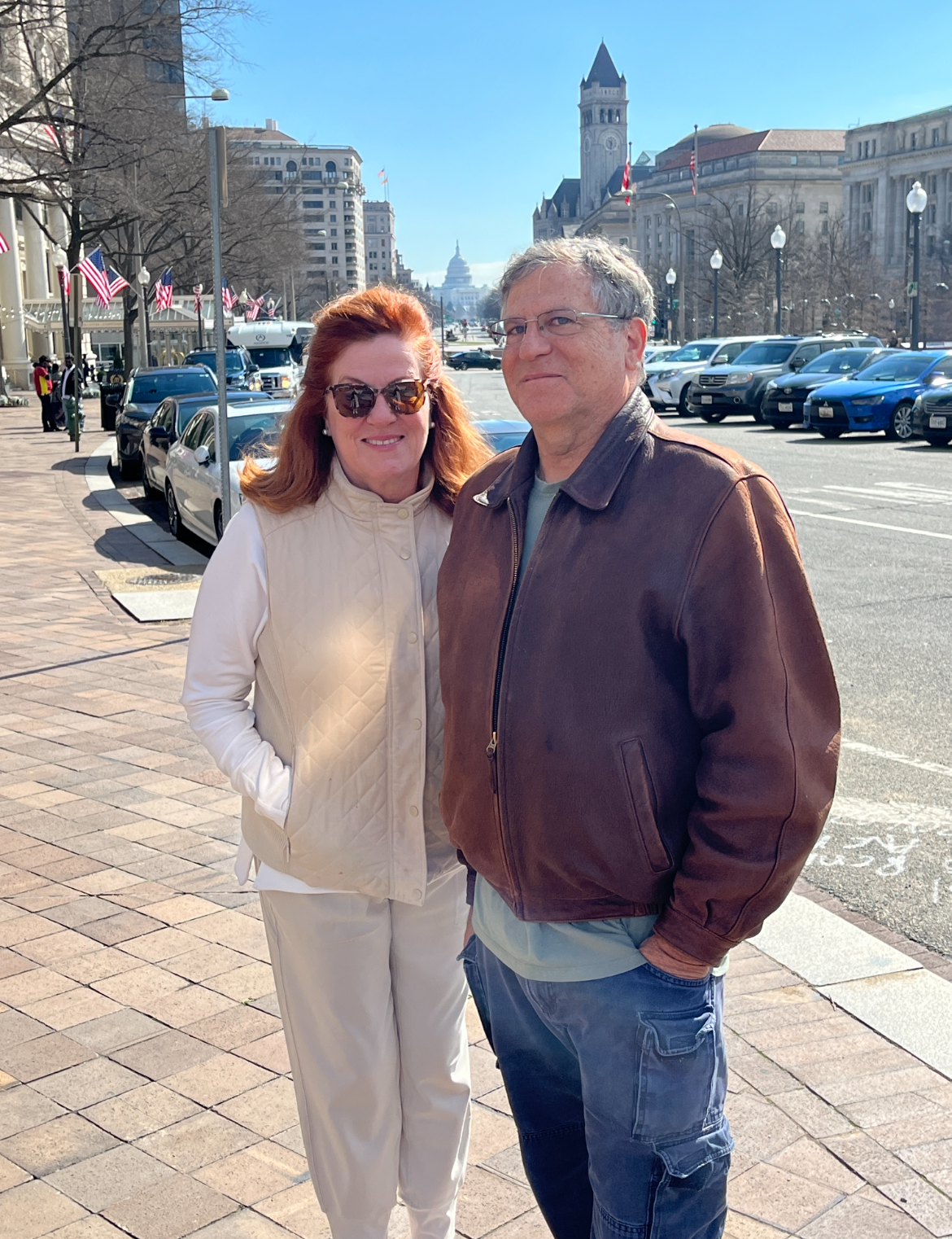 A person and person standing on a sidewalk

Description automatically generated