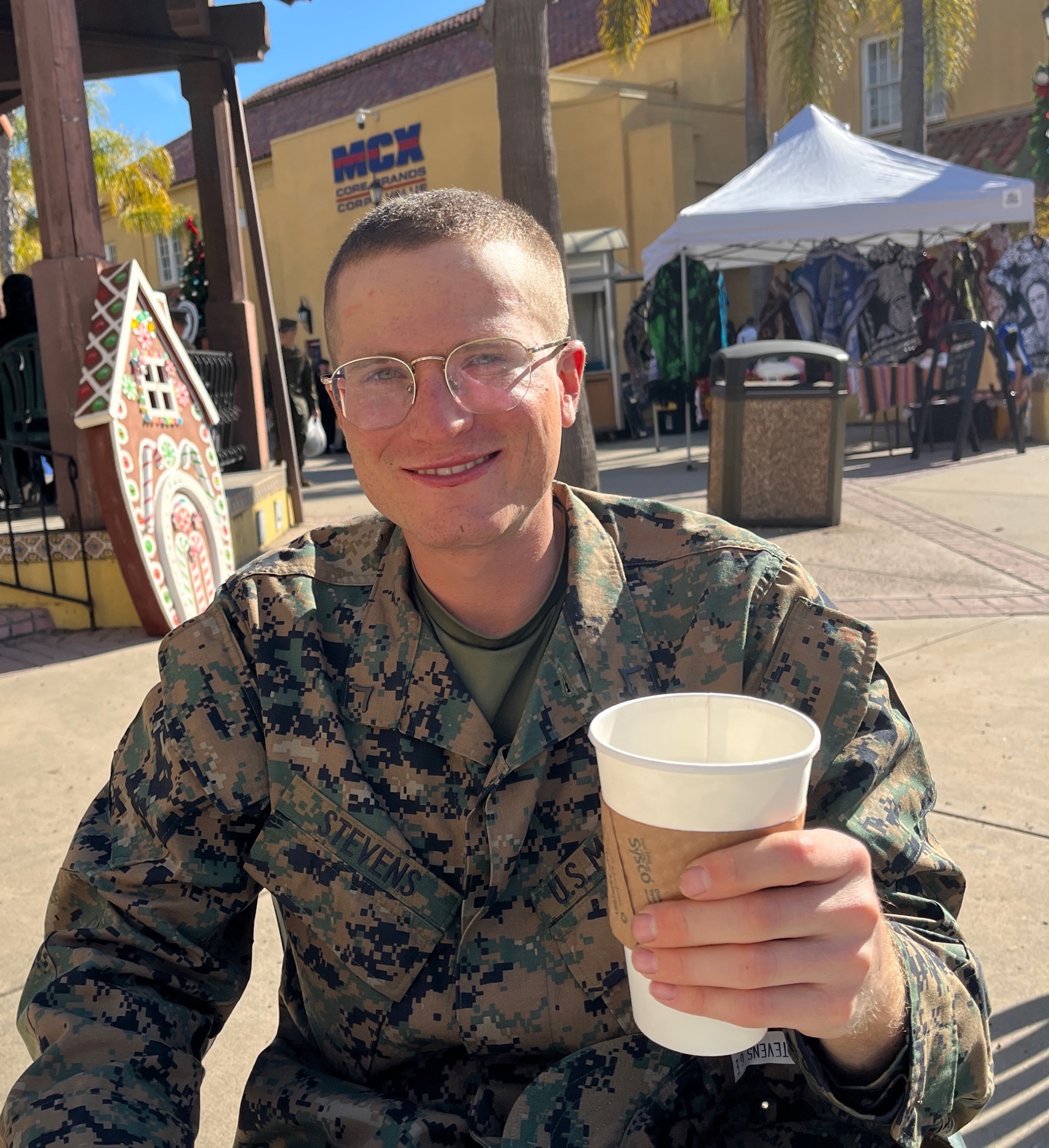 A person in military uniform holding a cup
Description automatically generated